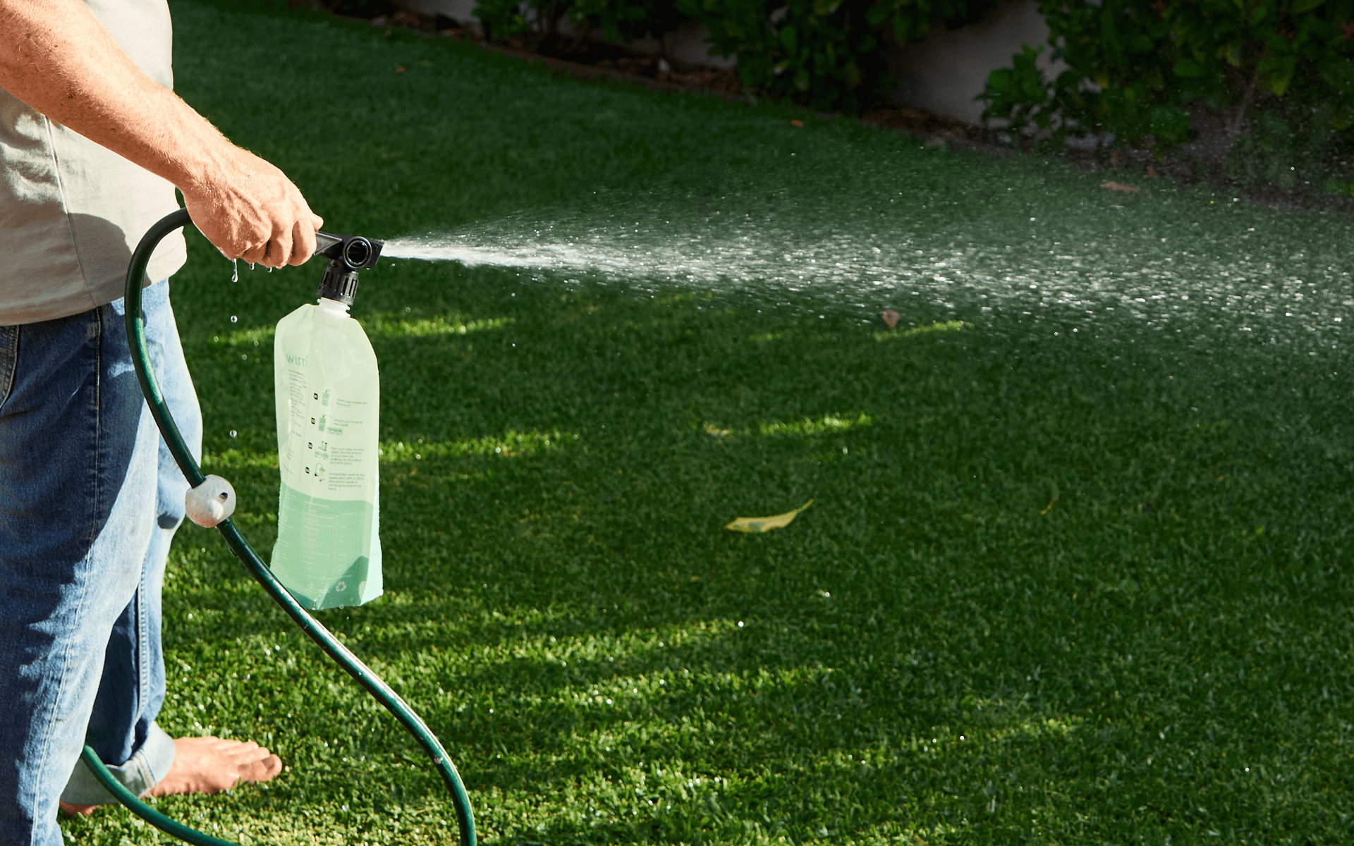 Australian Lawn Care - man watering lawn with a soil mix product