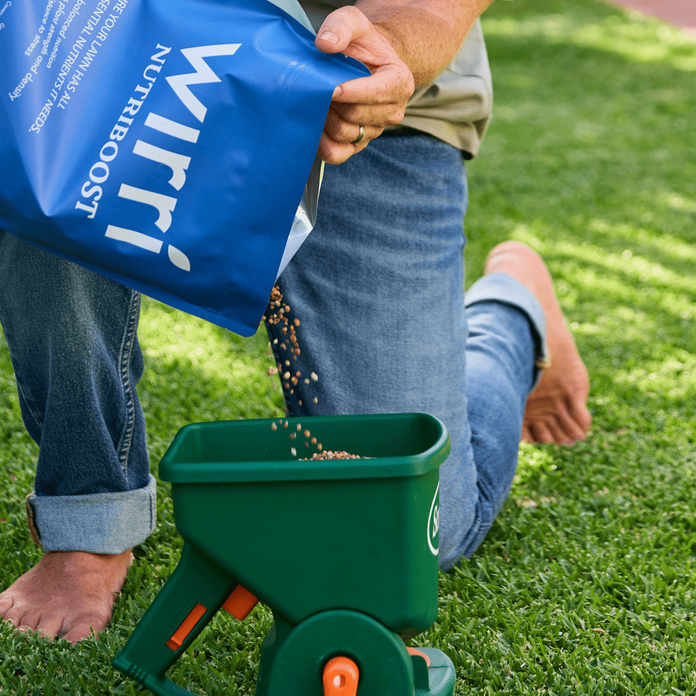 Australian Lawn Care - Man setting granular fertiliser in container