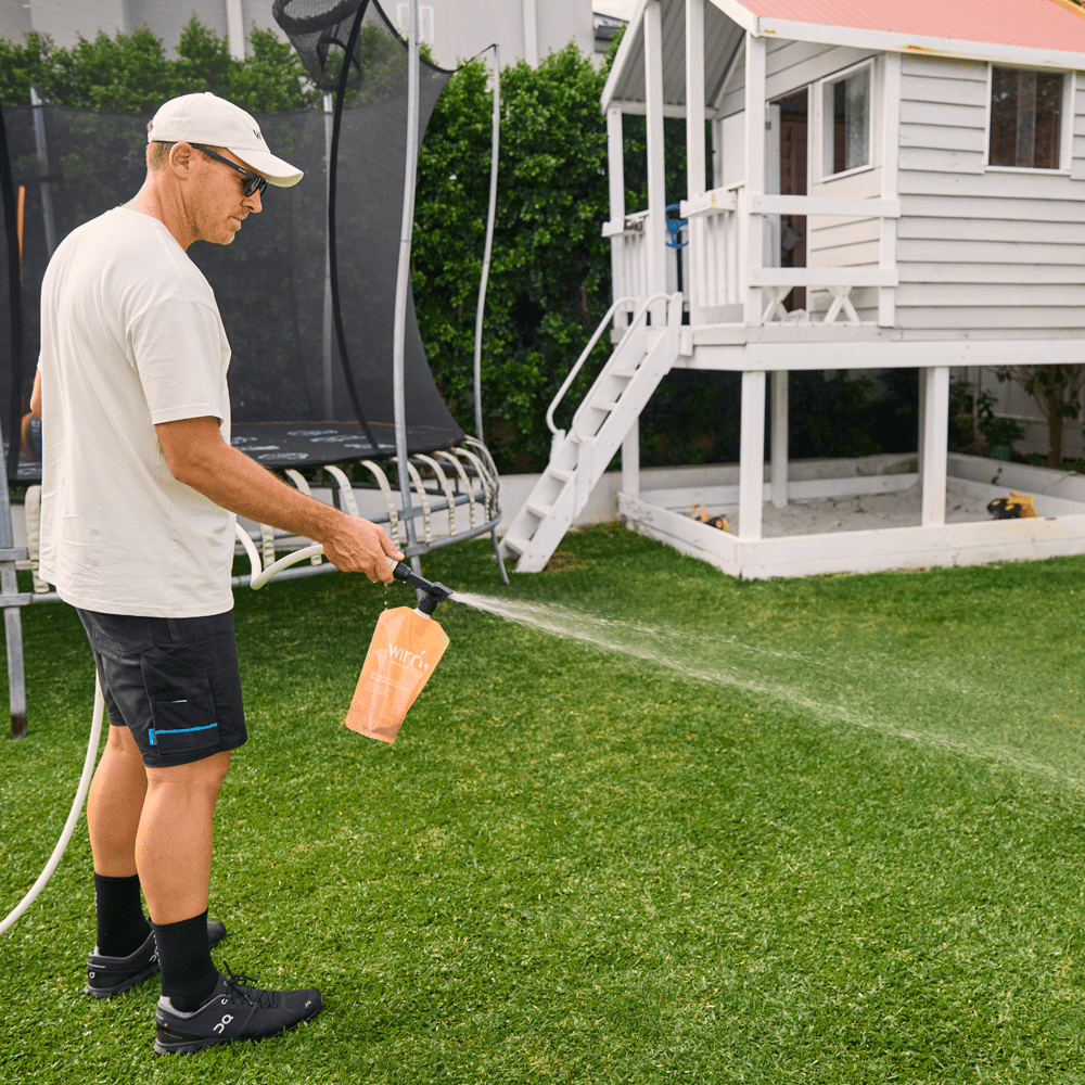 Pre-winter Lawn Care - Man using lawn care product